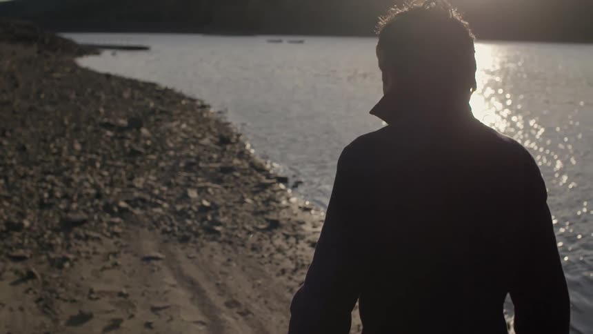 A man is walking down a river