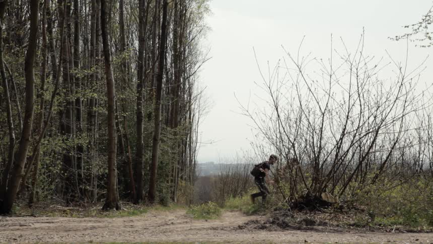 Two men walking out of the woods and into a field