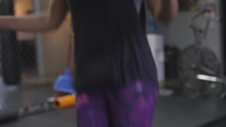 A woman jumps rope in a gym