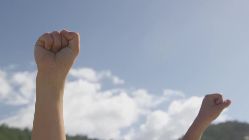 Two fists clench in the air