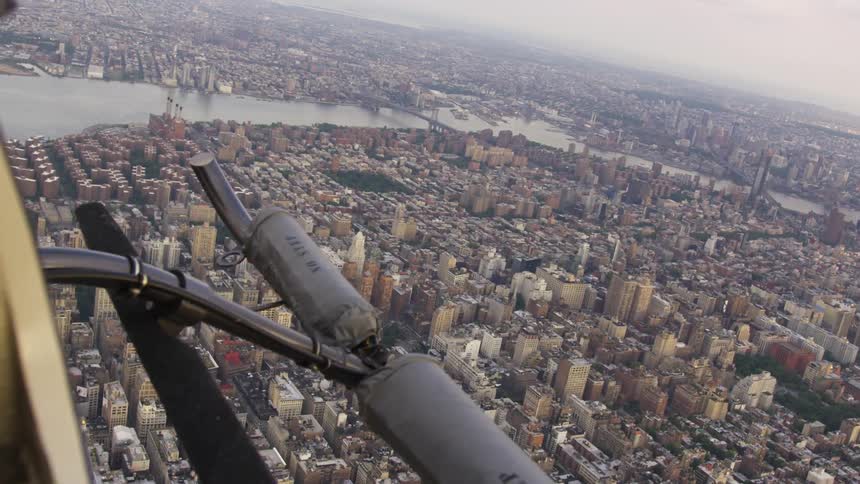The helicopter flies above the city