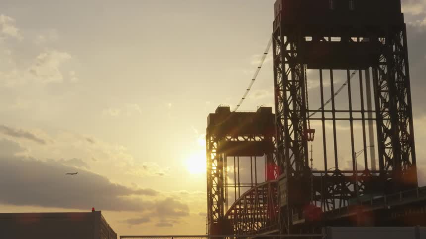 Cars drive over a bridge at sunset