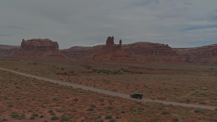 Suv drives on desolate road in the desert