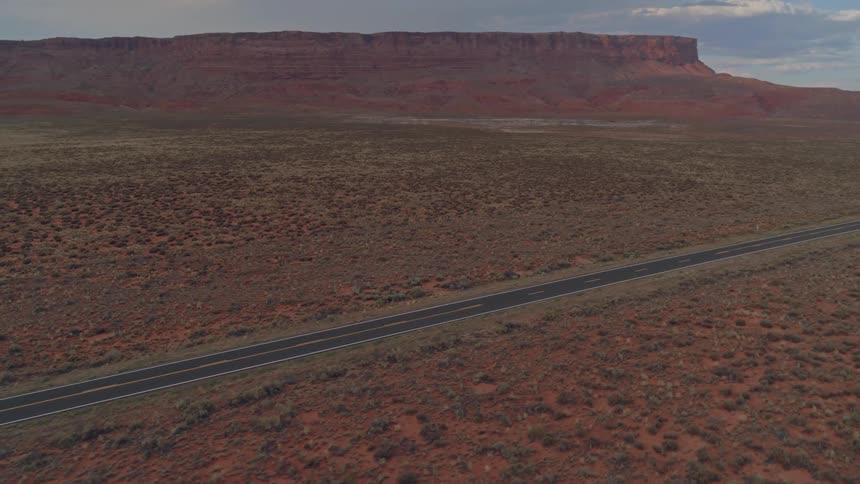 Drone footage of a wide open road in the desert