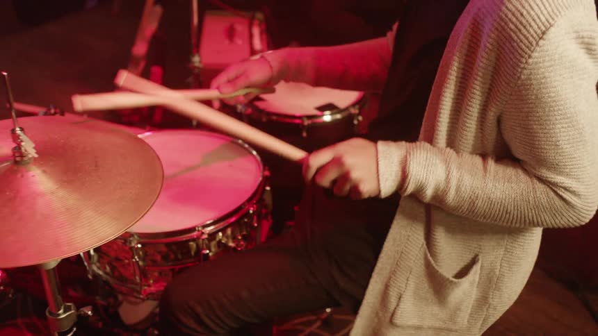 A man is playing the drums indoors