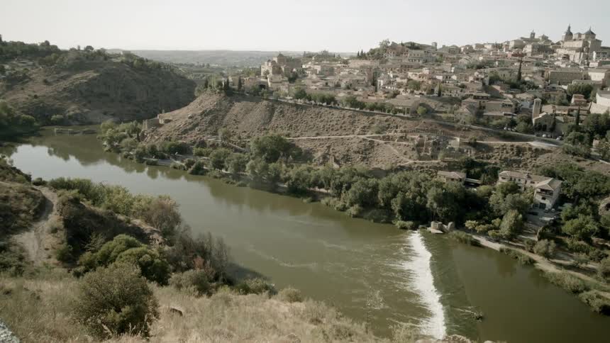 A large river flows between mountains lined with trees