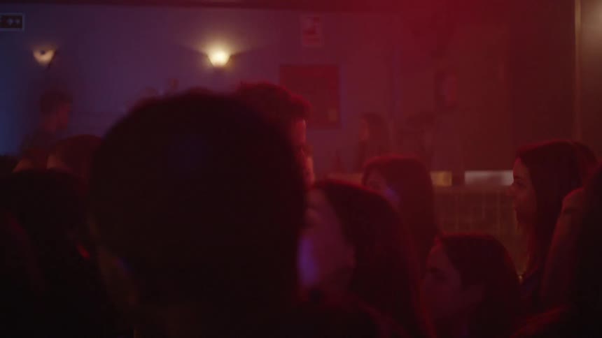 A crowd is dancing and drinking beer in a bar
