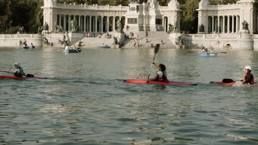 People kayaking and boating in waters by large arches
