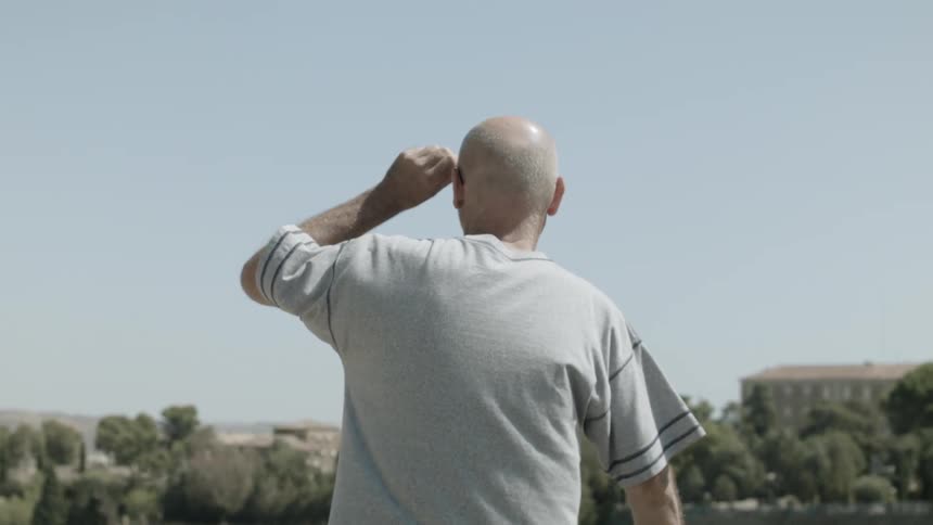 A man stands and looks out across the lake
