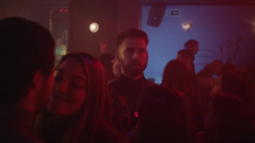 Man walking through a crowded club looking for someone