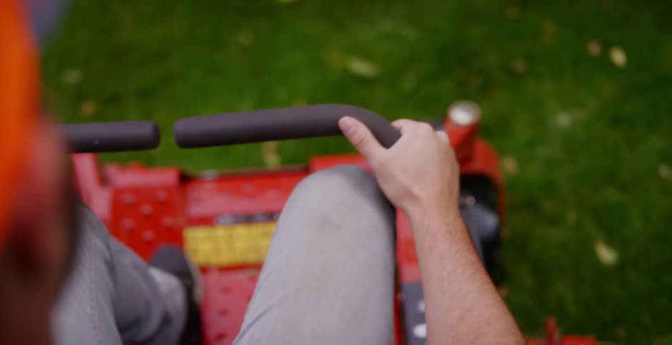 A person is riding a lawn mower outside