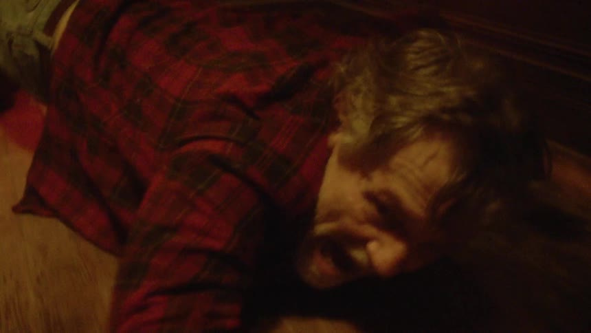 A man is dragged through the hall
