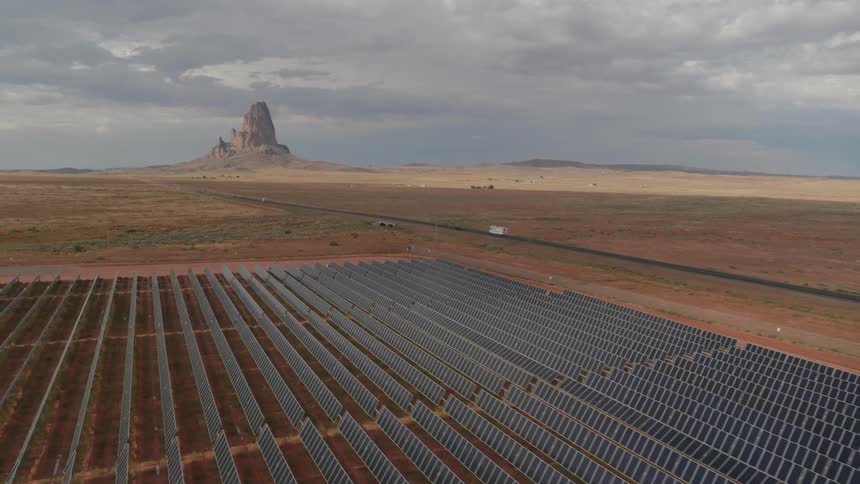 Solar panels and road are set in a rural, flat and arid landscape