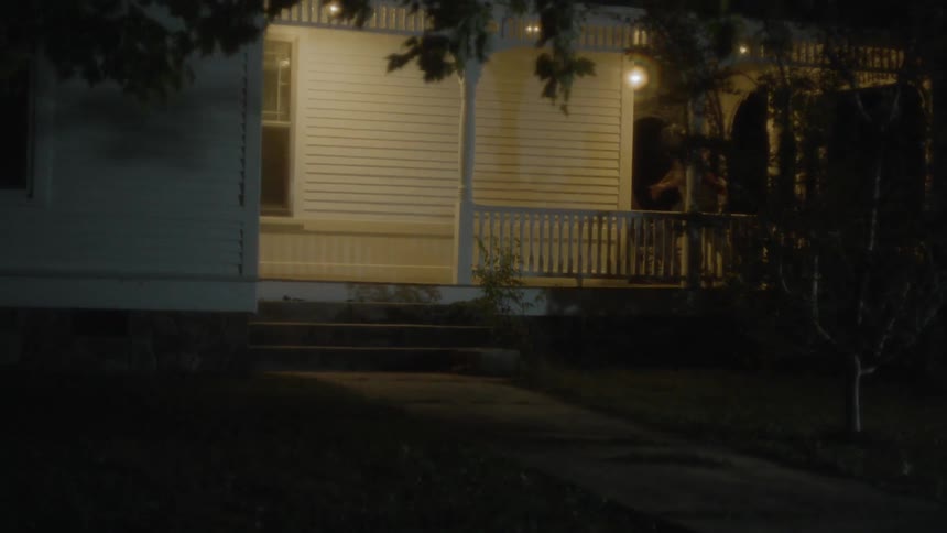 The lights in the house are flashing as a man runs out