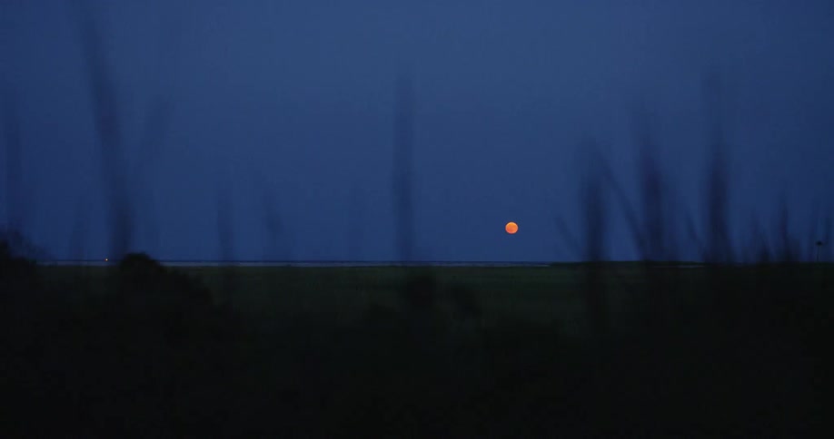 The sun setting over a large flat plain of land