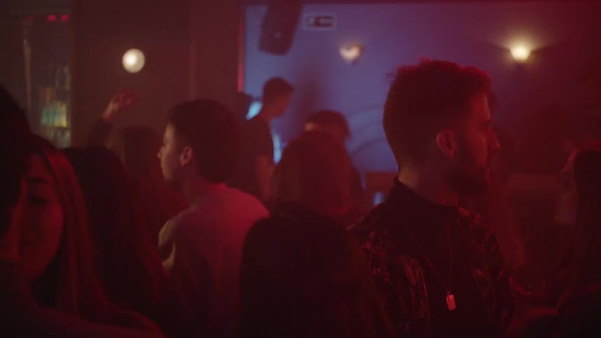 A crowded room with people talking and dancing