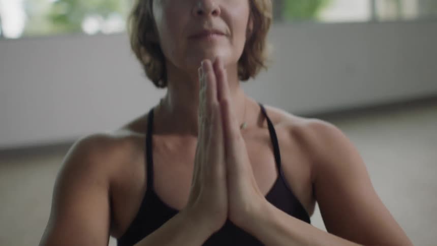 A woman does yoga while smiling