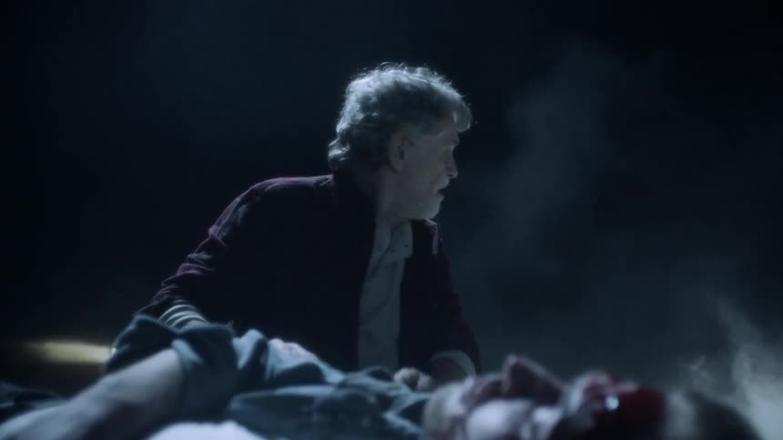 A man tries to wake an injured man at night