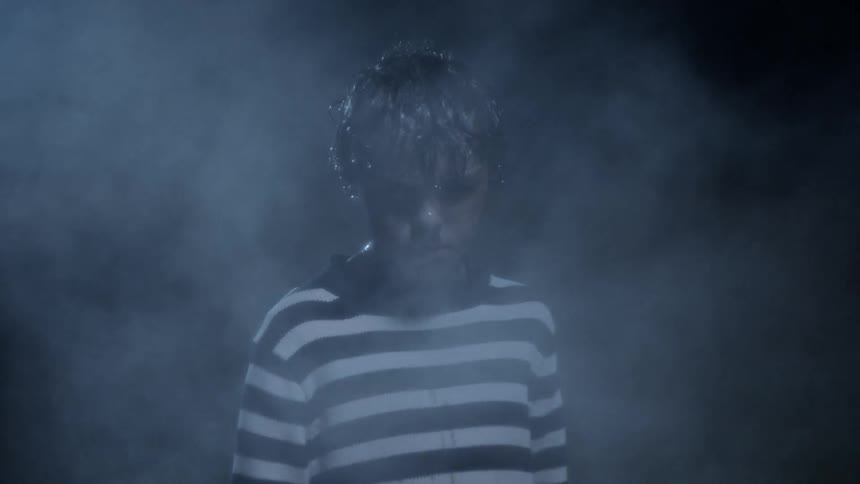 A boy is outdoors at night