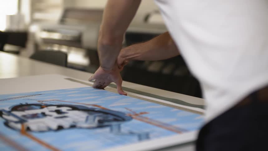 A man making cuts into a picture