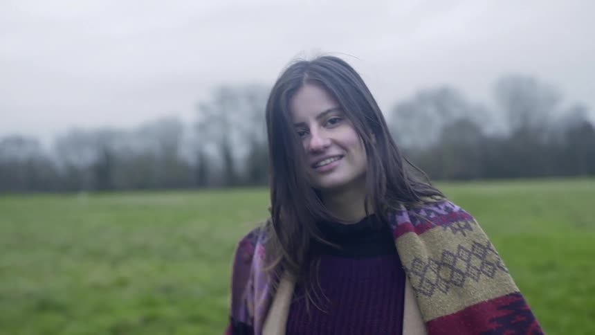 Woman walking through a field and smiling