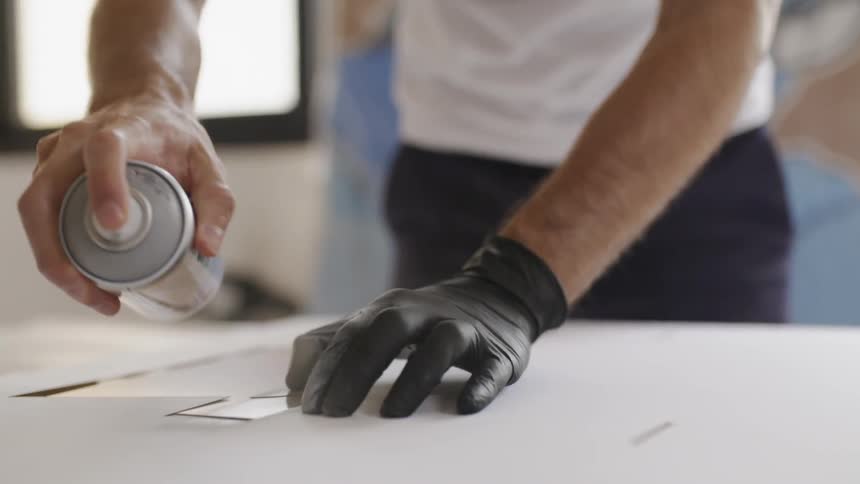 Man sprays from aerosol can onto surface