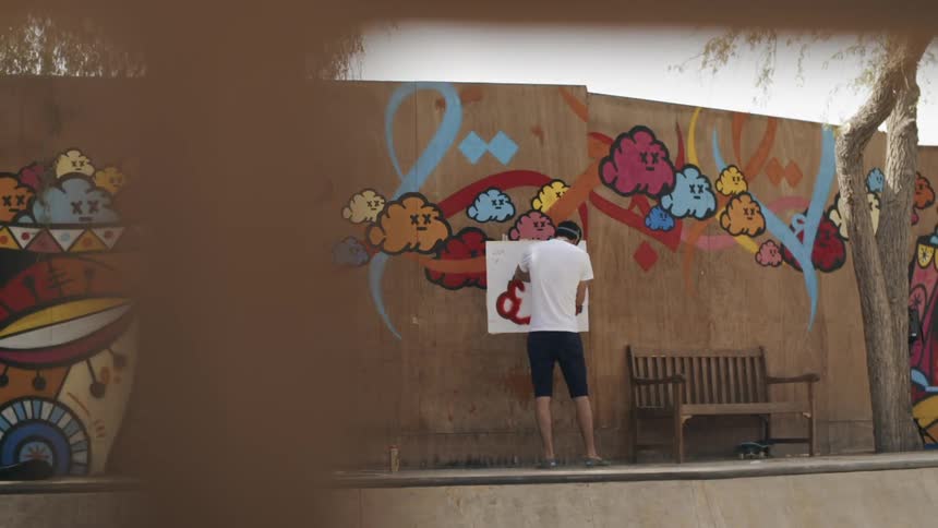 A man is outside looking at a wall