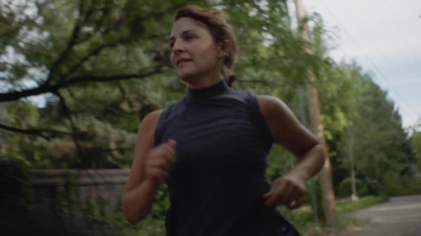 A woman is jogging down the road