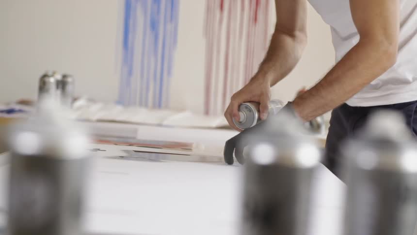 A man spray painting on a table
