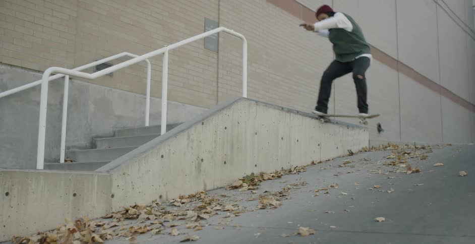 A man jumps on a concrete ledge while skateboarding