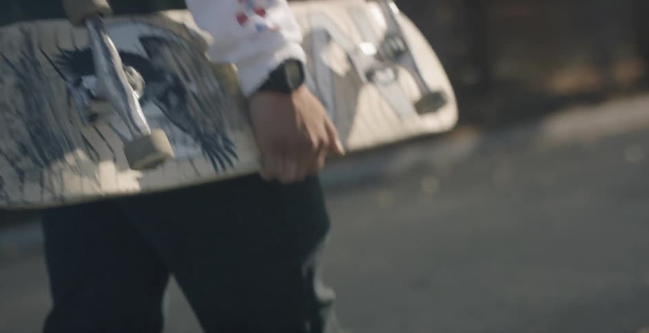 A man carries his skateboard