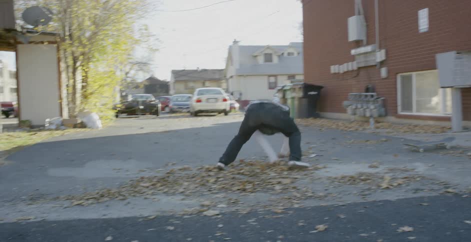 Skateboarder attempting a rail grind on stairs and falling
