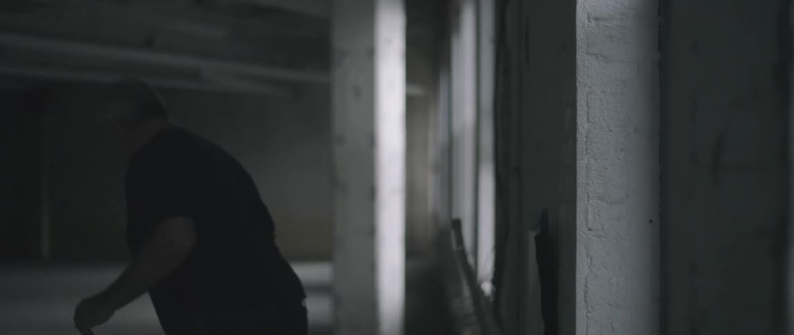 A person running and leaping inside an empty building