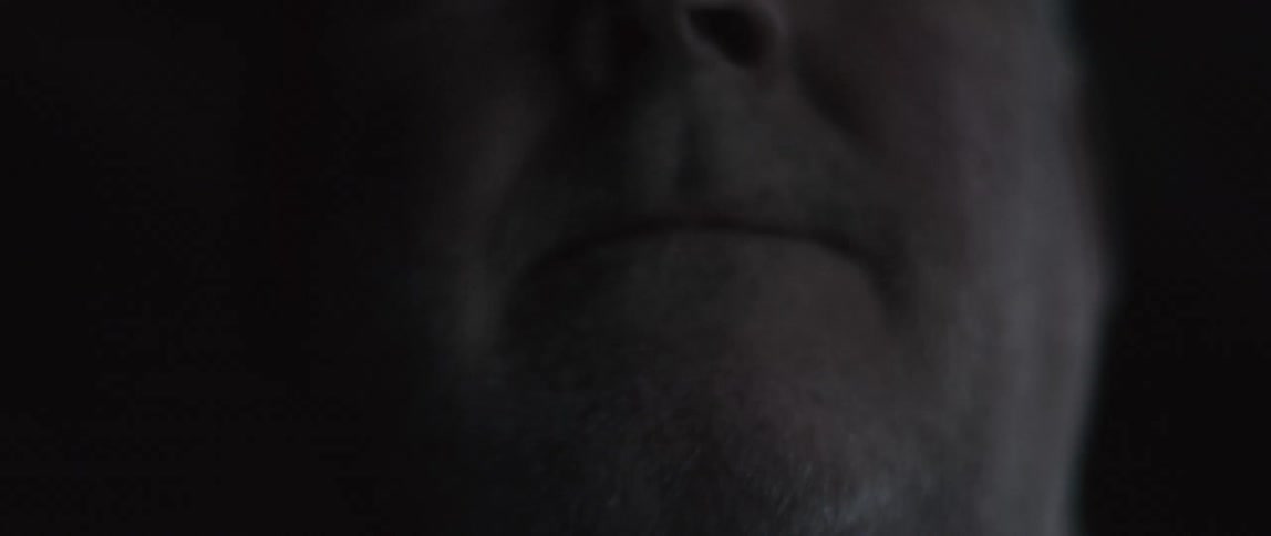 A man frowns in the dark