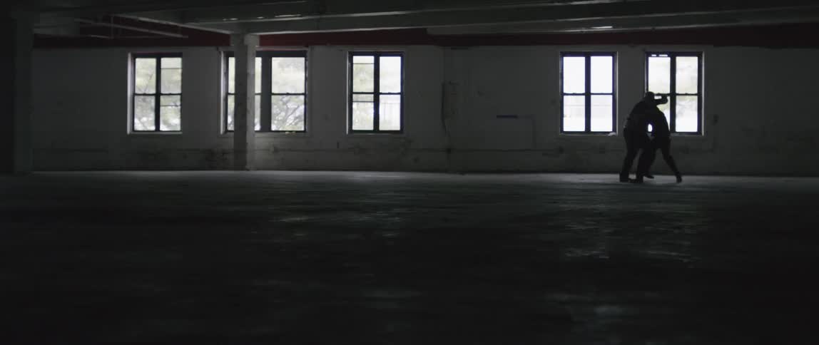Two people dancing in an abandoned building