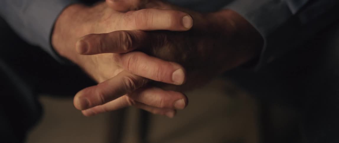 A man is holding his hands together