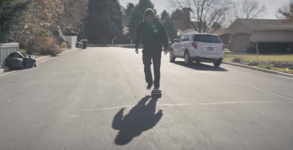 Man skateboards down residential street