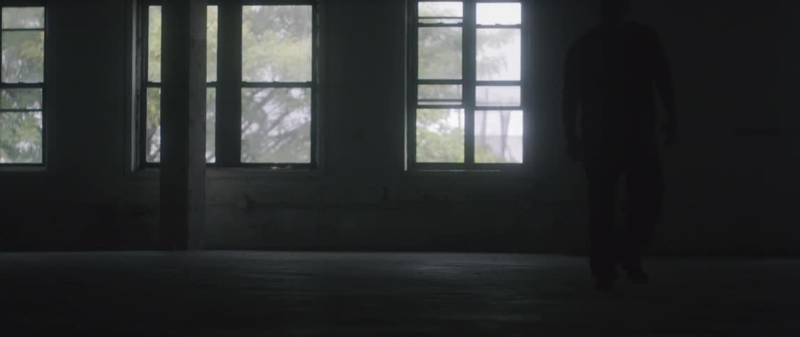 A man walks through a dimly lit room