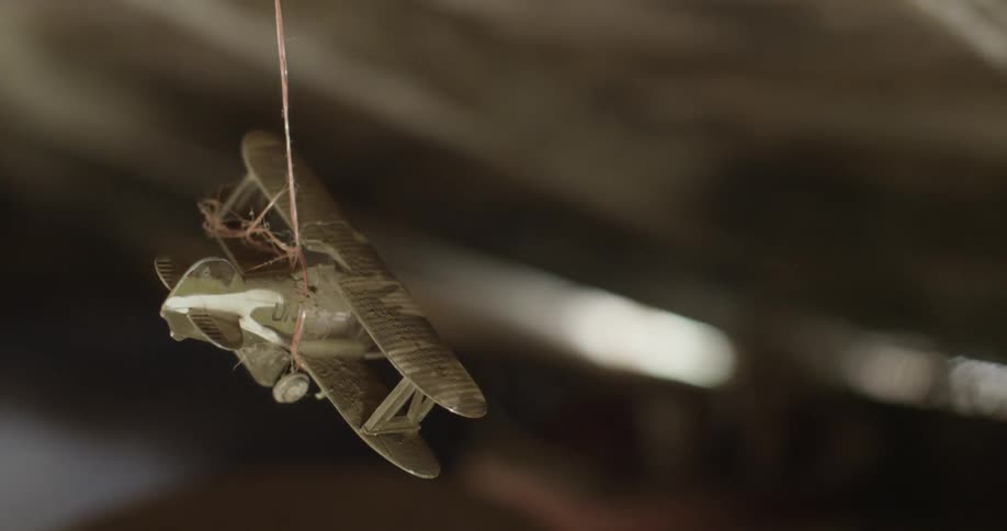 Small toy airplane hanging from a thin string