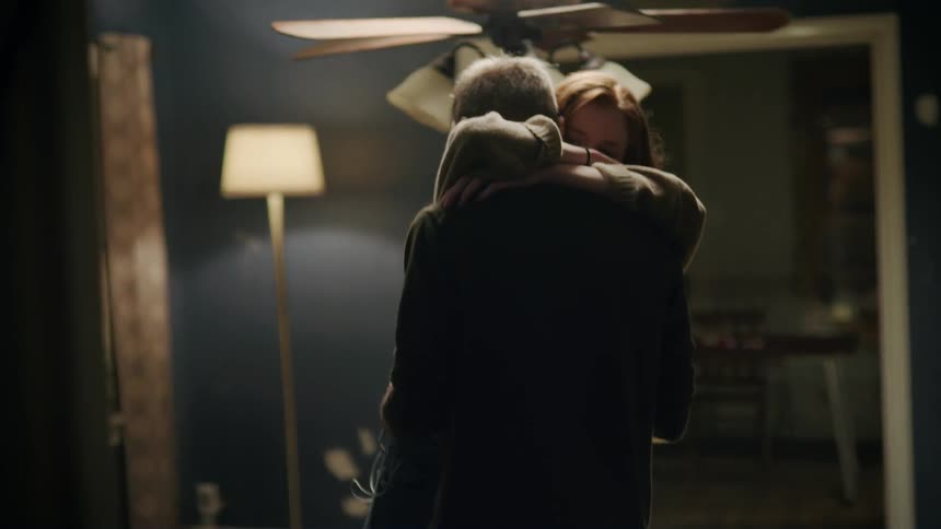 Man and woman slow dance in empty apartment room