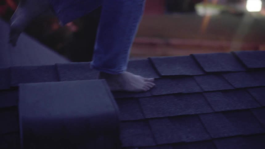 The woman is balancing walking over the roof