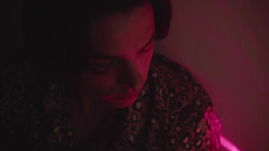 A person is sitting inside in the dark