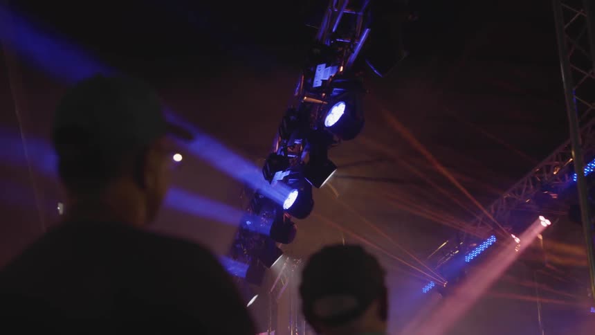 Lights beam overhead in a venue