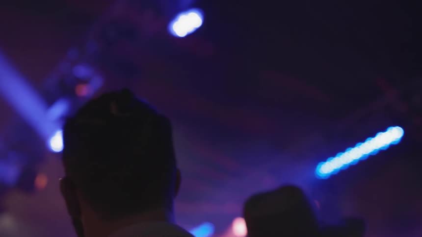 People dance together in the dark club