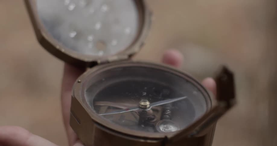Hand holding a large wooden compass