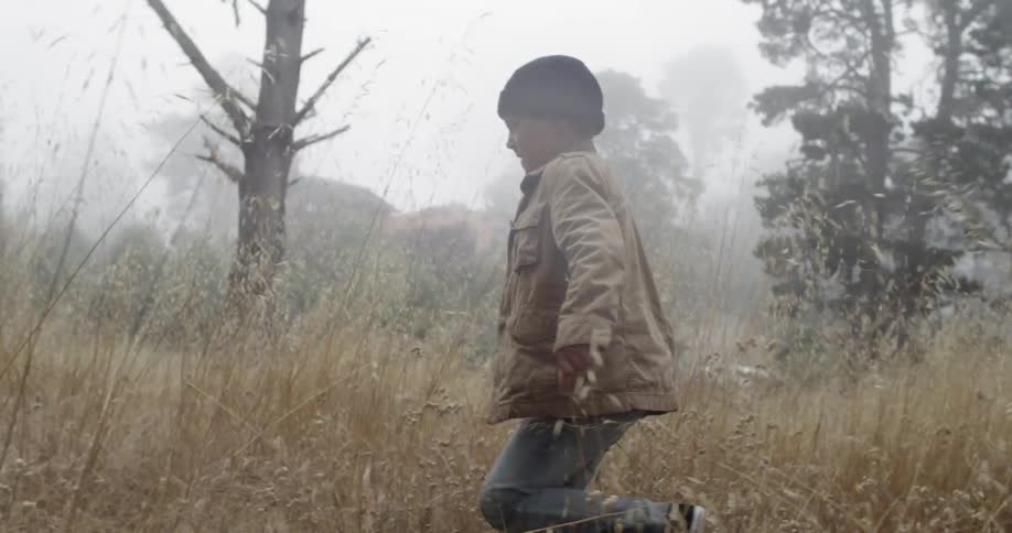 A boy running through tall grass