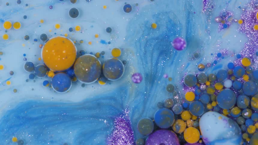 Colored bubbles flow on blue paint