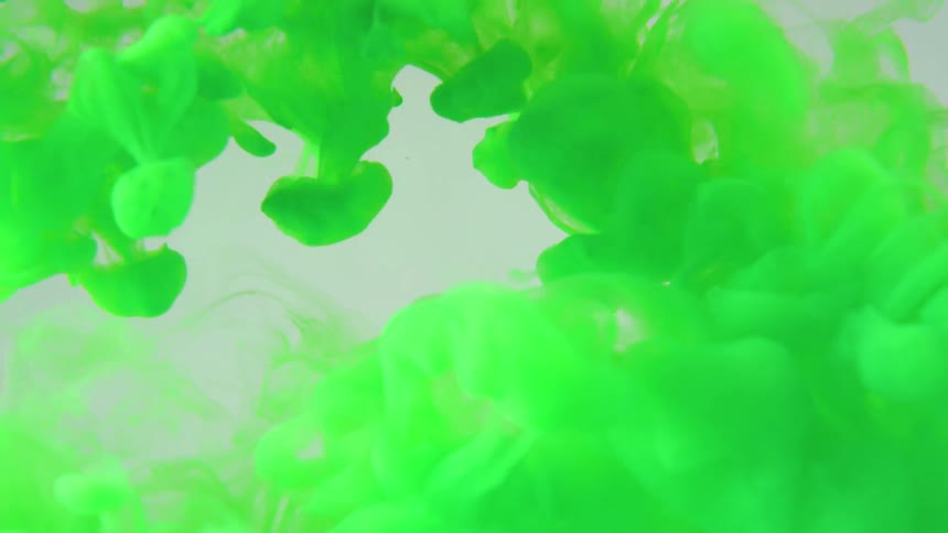 A cloud of green ink is moving in the clear water