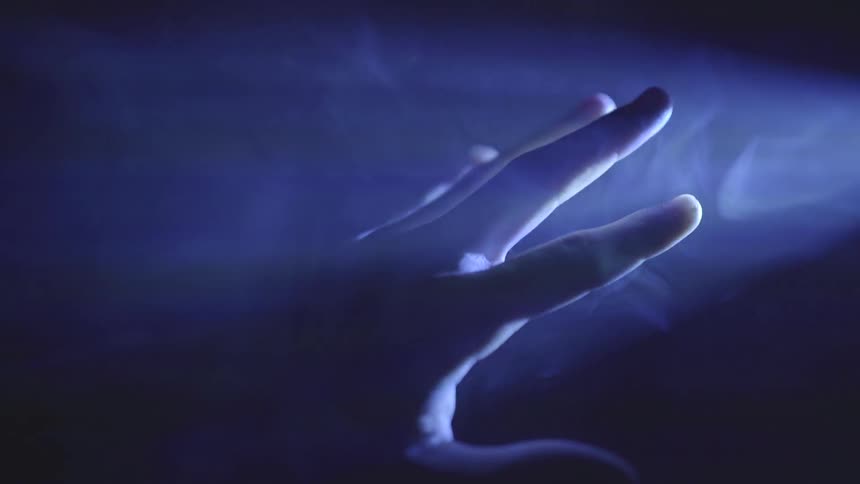 A hand glimmering different colors of light off it