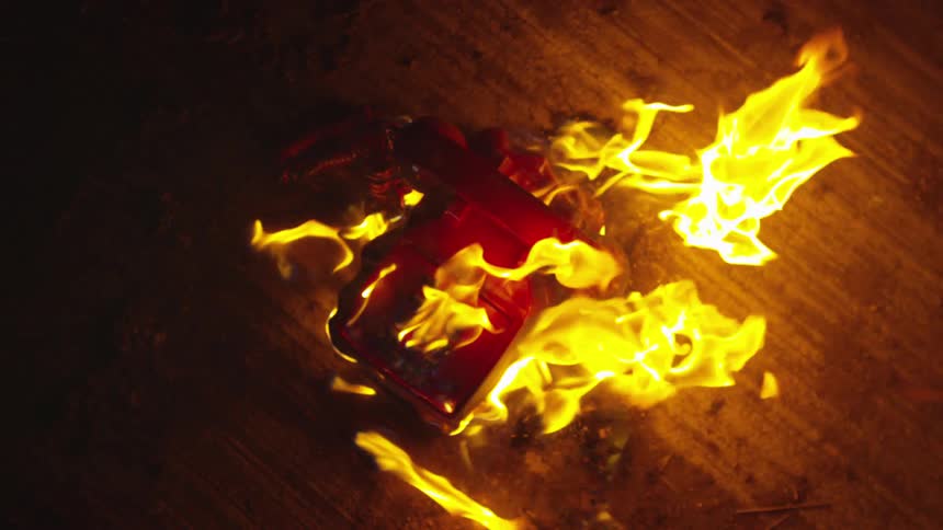 An old phone burning on the ground